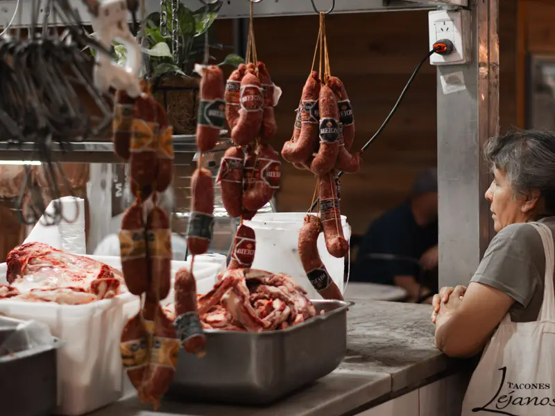 Mostrador de una carnicería con chorizos colgados y cortes de carne
